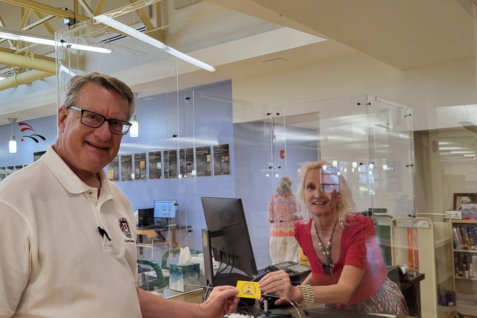 Talbot County Manager Clay Stamp receiving his library card at the Easton Branch of TCFL.