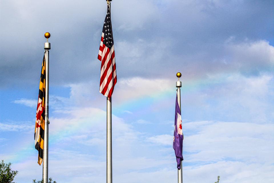 A brief, but sudden downpour occurred right before the ceremony, leading to a beautiful rainbow behind the flags. Photo courtesy of Talbot County Government/Sarah Kilmon.