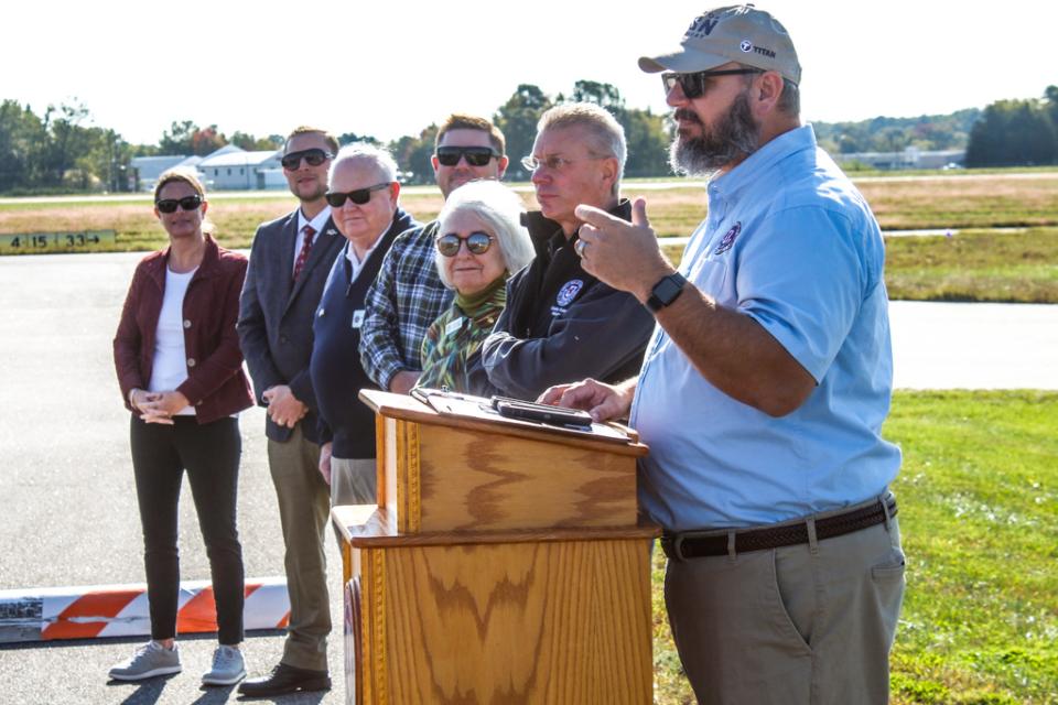 Micah Risher, Easton Airport Manager, offers words of thanks to all the partners involved in the project, as Town and County Council Members and the Mayor look on.
