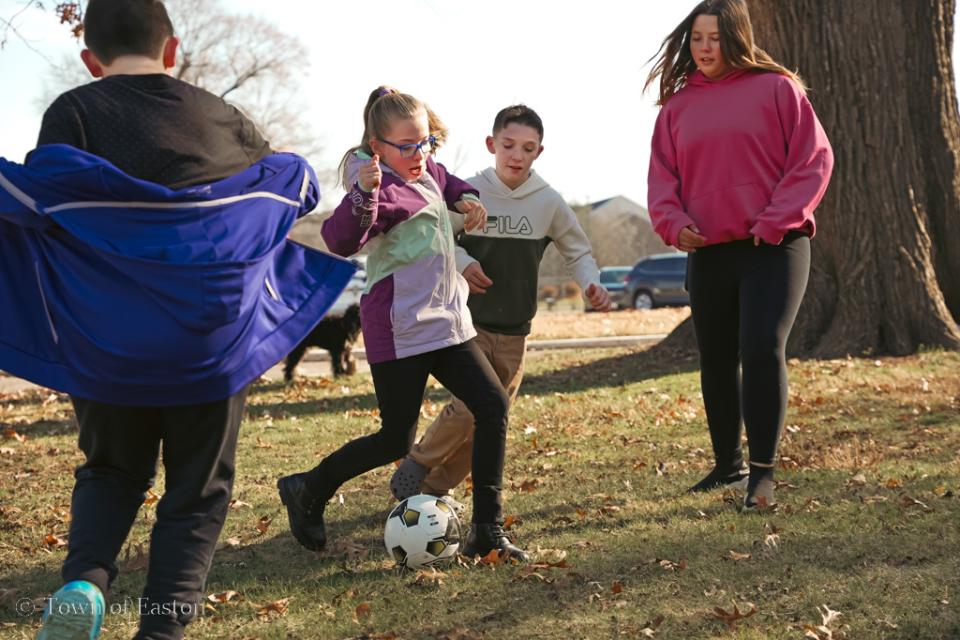 Friends and staff enjoy a friendly game of soccer after wrapping presents.