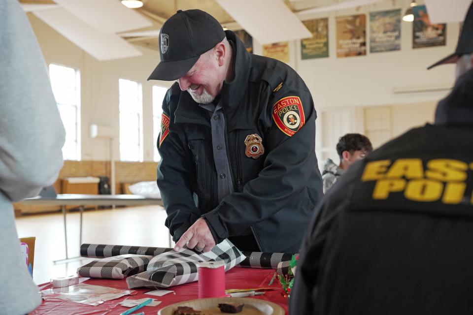 Easton Chief of Police Alan Lowrey helps to wrap gifts purchased at the Talbot Optimist Club&#039;s &#039;Shop With a Cop&#039; event.