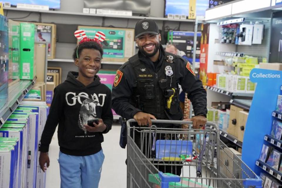PFC Cordero Proctor from Easton Police Department helps a local youth from Talbot Mentors shop at Walmart for the Talbot Optimist Club&#039;s &#039;Shop With a Cop&#039; event.